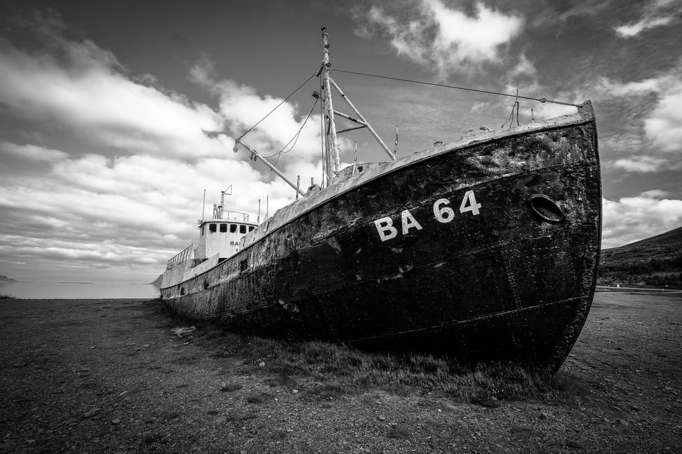 Grayscale Photography of Abandoned Cargo Ship on Field